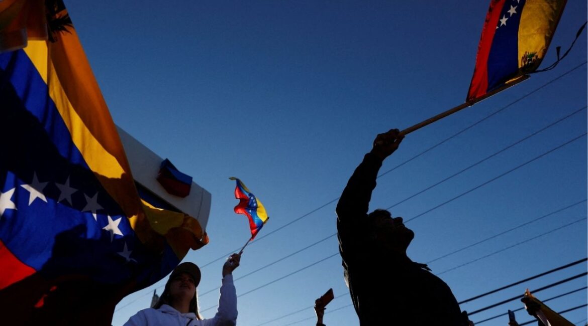 People holding Venezuelan flags react to the news after U.S. President Donald Trump said the U.S. has struck Venezuela and captured its President Nicolas Maduro, in Doral, Miami, Florida, U.S., January 3, 2026. REUTERS/Marco Bello
