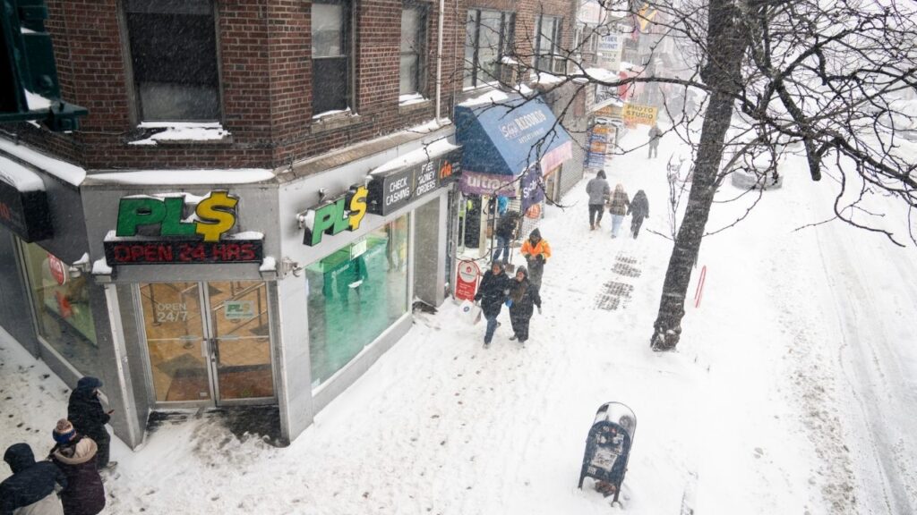 People on a sidewalk during a winter snowstorm in the Corona neighborhood of Queens on Sunday, Jan. 25, 2026. (Janice Chung/The New York Times)
