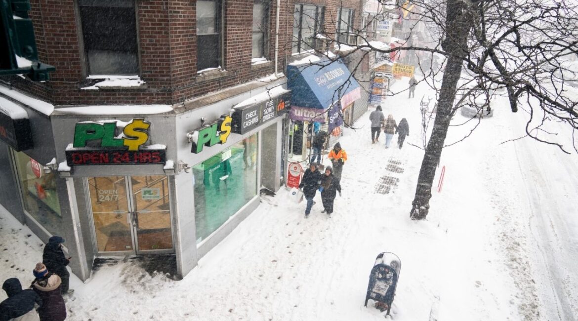 People on a sidewalk during a winter snowstorm in the Corona neighborhood of Queens on Sunday, Jan. 25, 2026. (Janice Chung/The New York Times)