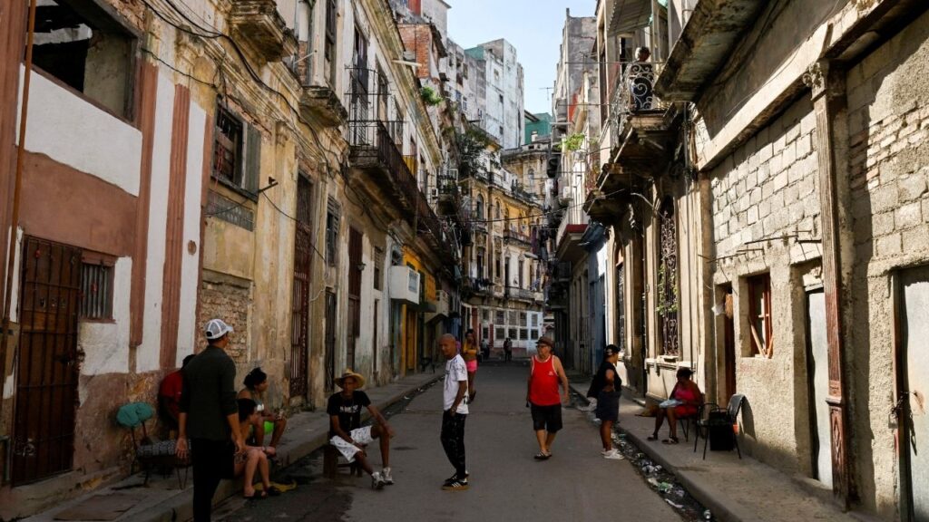 People spend time on a street sidewalk, as U.S.-Cuba tensions rise after U.S. President Donald Trump vowed to stop Venezuelan oil and money from reaching Cuba and suggested the communist-run island strike a deal with Washington, in Havana, Cuba, January 11, 2026. (Reuters/Norlys Perez)