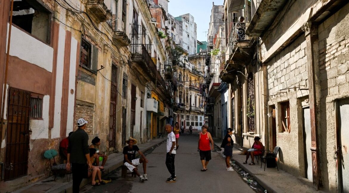 People spend time on a street sidewalk, as U.S.-Cuba tensions rise after U.S. President Donald Trump vowed to stop Venezuelan oil and money from reaching Cuba and suggested the communist-run island strike a deal with Washington, in Havana, Cuba, January 11, 2026. (Reuters/Norlys Perez)