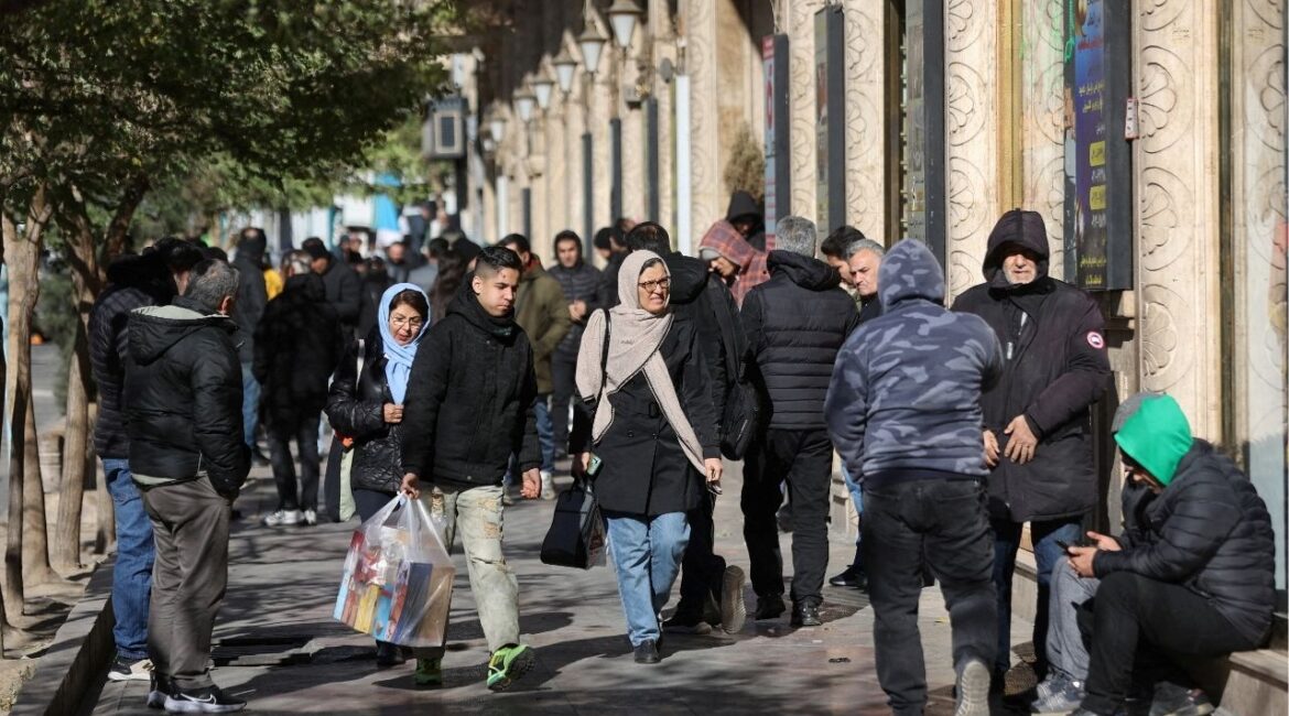 People walk past stores as the value of the Iranian Rial drops, in Tehran, Iran, December 30, 2025. (Reuters File)