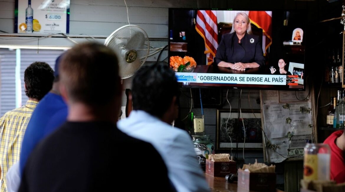 People watch television at a bar as Puerto Rico's Governor Wanda Vazquez Garced makes an address regarding the debt restructuring proposal filed in court by an oversight board, in San Juan, Puerto Rico, September 27, 2019. (Reuters/Ricardo Arduengo)
