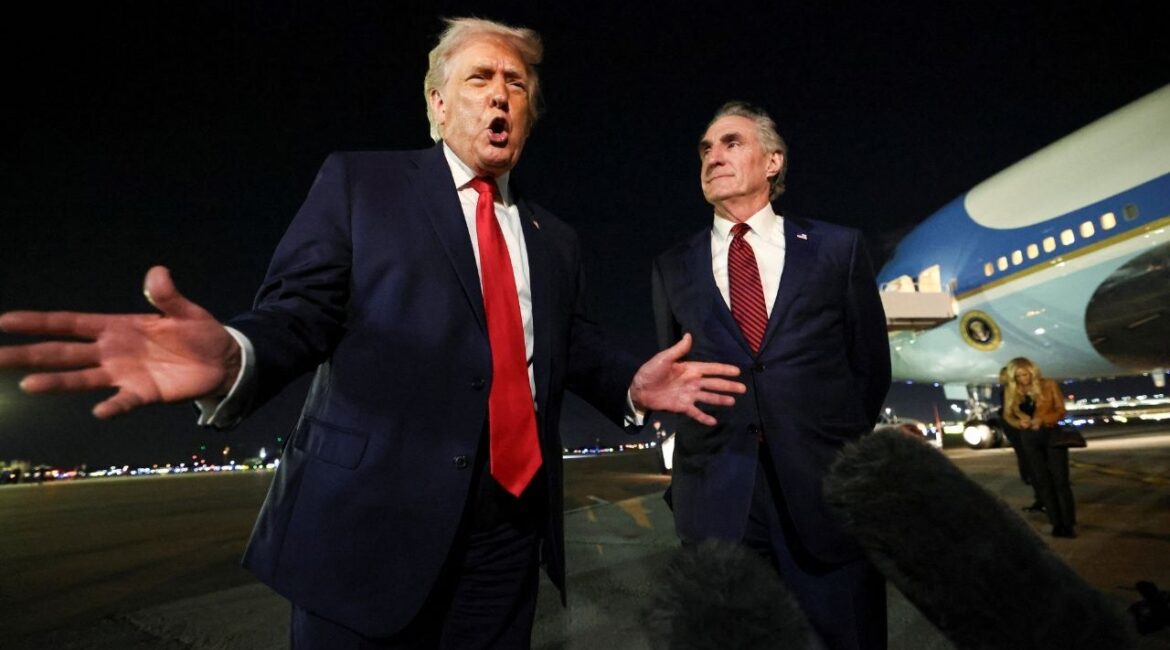 President Donald Trump speaks to members of the media, alongside Secretary of the Interior Doug Burgum, ahead of boarding Air Force One to depart for Washington, at Palm Beach International Airport in West Palm Beach, Florida, U.S., January 19, 2026. (Reuters/Kevin Lamarque)