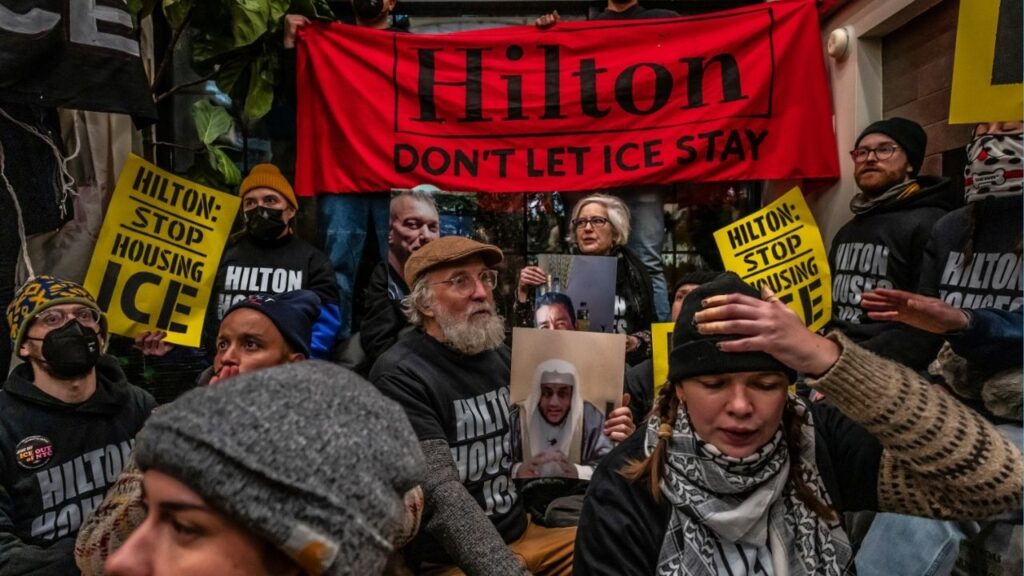 Protesters condemning Immigration and Customs Enforcement gather in the lobby of a Hilton Garden Inn in New York, on Tuesday, Jan. 27, 2026. The protesters directed their ire at Hilton for, they claimed, providing lodging to ICE agents. (Ashley Gilbertson/The New York Times)