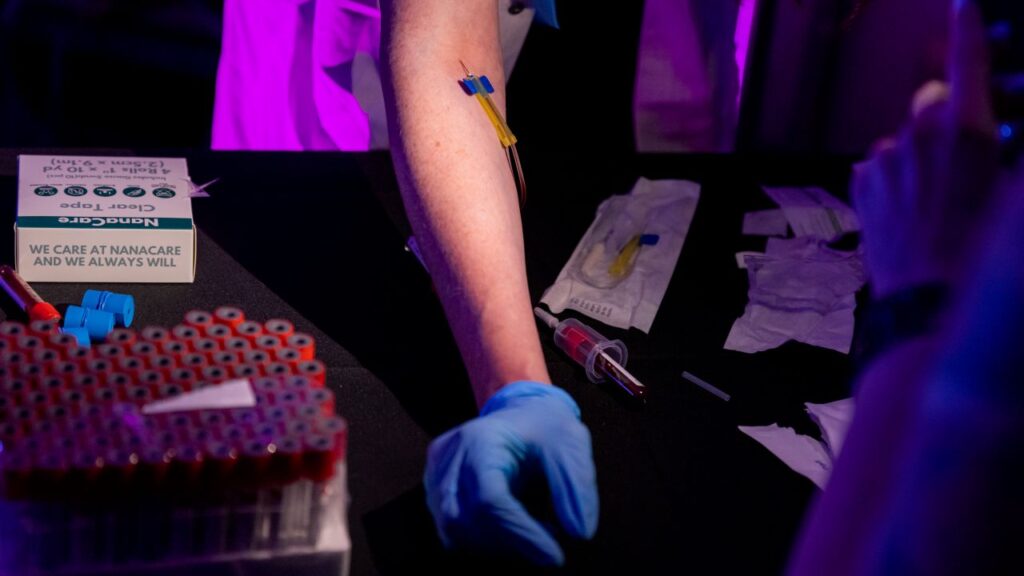 Image of a person being taught how to inject peptides into the arm