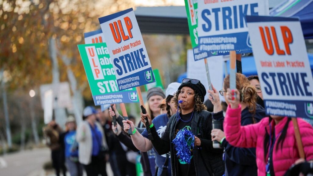 Striking members of the United Nurses Associations of California and Union of Health Care Professionals hold signs along the picket line outside a Kaiser Permanente hospital in San Diego, California, U.S., January 26, 2026. (Reuters/Mike Blake)