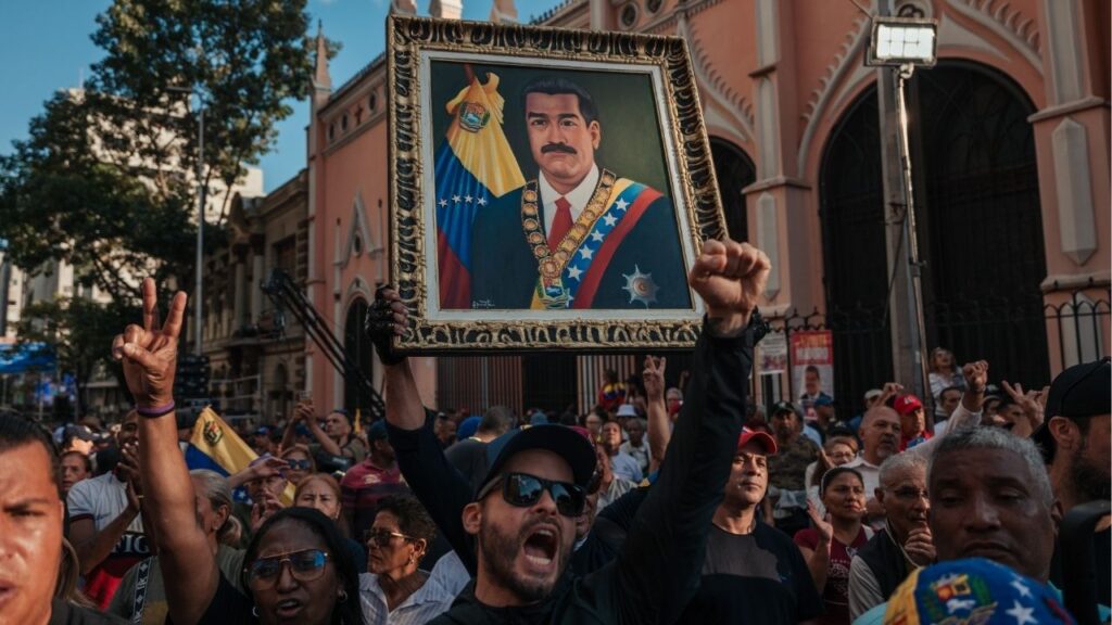 Supoprters of President Nicolás Maduro of Venezuela hold up a portrait of him as they gather near Miraflores Palace in Caracas, Venezuela, on Sunday, Jan. 4, 2026, to demand the release of Maduro after he was captured by the United States. (The New York Times)