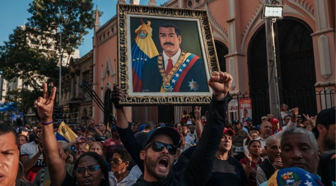 Supoprters of President Nicolás Maduro of Venezuela hold up a portrait of him as they gather near Miraflores Palace in Caracas, Venezuela, on Sunday, Jan. 4, 2026, to demand the release of Maduro after he was captured by the United States. (The New York Times)