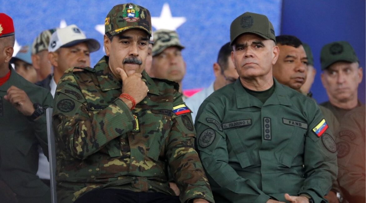 Venezuela's President Nicolas Maduro sits with Defence Minister Vladimir Padrino Lopez during a rally against a possible escalation of U.S. actions toward the country, at Fort Tiuna military base in Caracas, Venezuela, November 25, 2025. REUTERS/Leonardo Fernandez Viloria