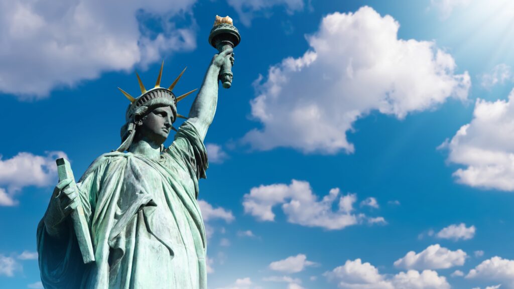 Image of the Statue of Liberty under a blue sky dotted with white clouds