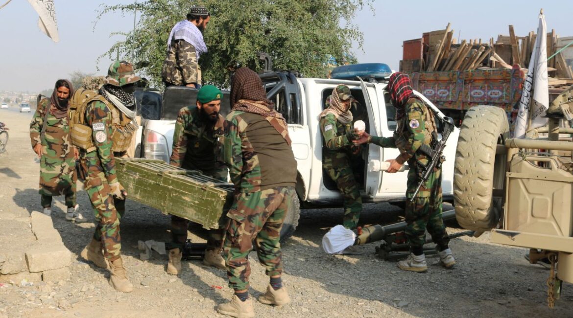 Image of Taliban soldier carrying a box of ammunition