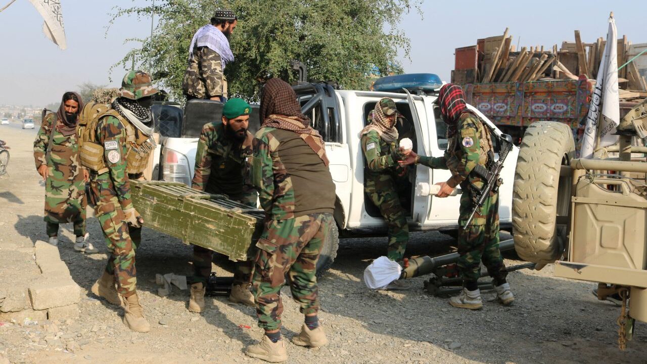 Image of Taliban soldier carrying a box of ammunition