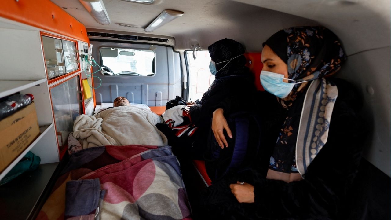 A Palestinian patient lies inside an ambulance, accompanied by relatives, as they make their way back to their homes after being informed by officials that their travel scheduled for today through the Rafah border crossing was postponed, in Khan Younis in the southern Gaza Strip, February 4, 2026. (Reuters/Mahmoud Issa)