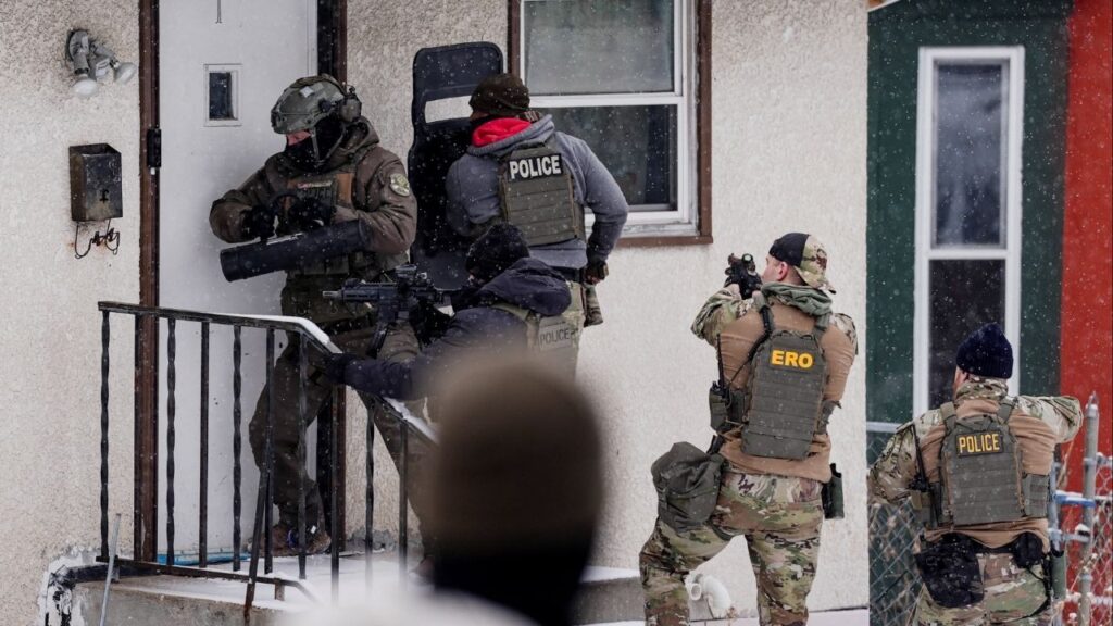 A law enforcement officer uses a battering ram to force entry into a home during an immigration raid in St. Paul, Minnesota, U.S., days after an ICE agent fatally shot Renee Nicole Good, January 18, 2026. (Reuters/Leah Millis)