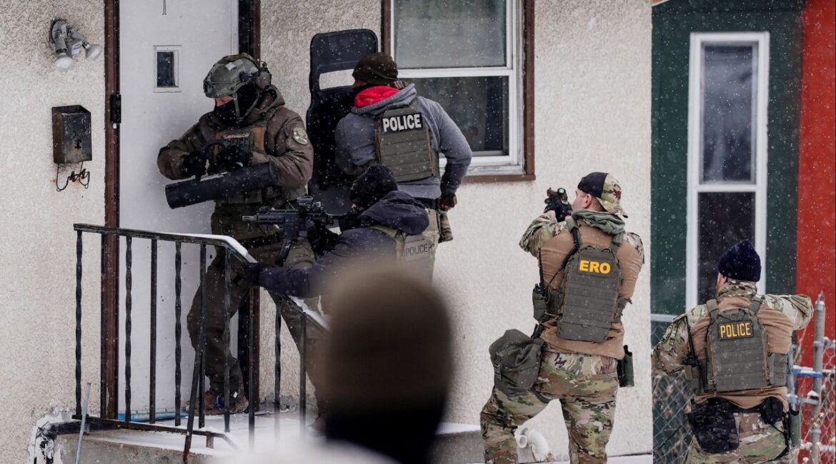 A law enforcement officer uses a battering ram to force entry into a home during an immigration raid in St. Paul, Minnesota, U.S., days after an ICE agent fatally shot Renee Nicole Good, January 18, 2026. (Reuters/Leah Millis)
