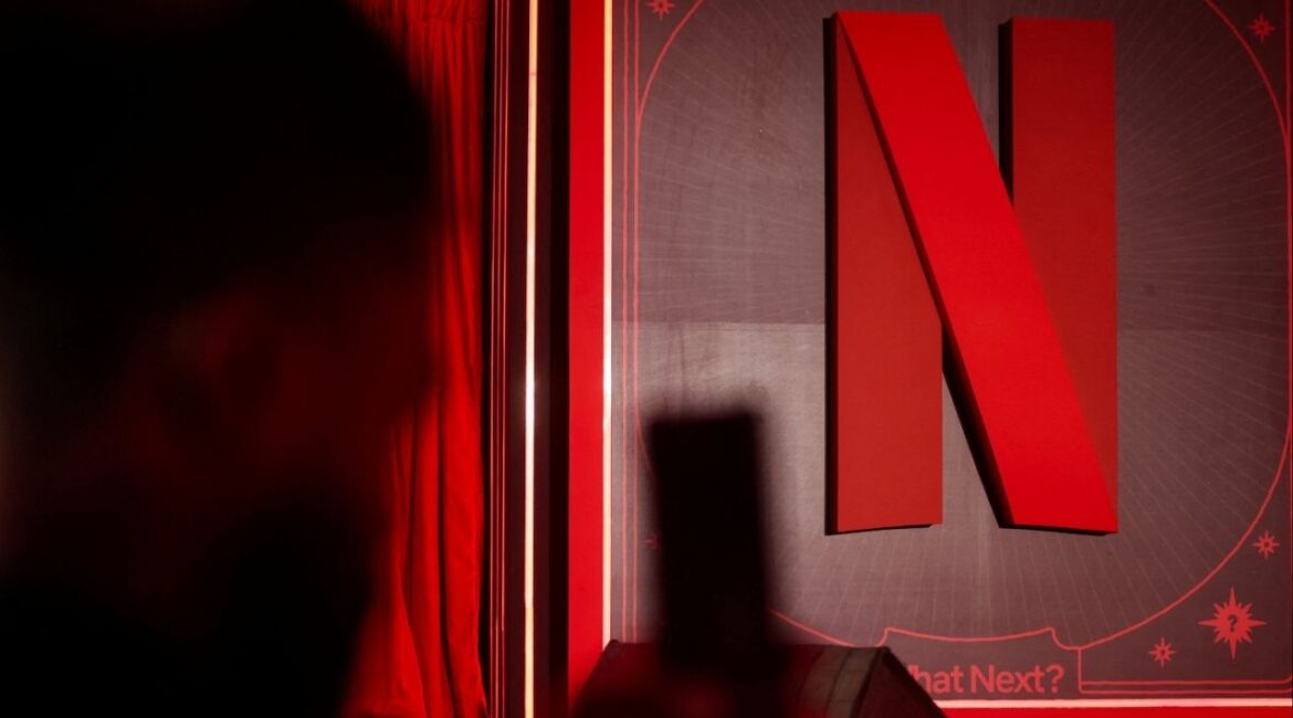A man takes a photograph next to a Netflix logo during an event in Mumbai, India, February 3, 2026. (Reuters/Francis Mascarenhas)