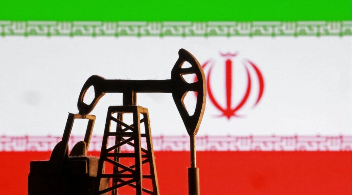A model of an oil pump is seen in front of an Iranian flag in this illustration taken January 9, 2026. (Reuters/Dado Ruvic/Illustration)