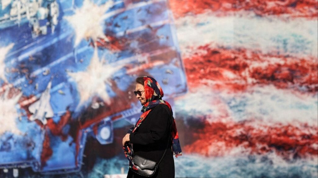 An Iranian woman walks past an anti-U.S. billboard in Tehran, Iran, February 26, 2026. (Majid Asgaripour/WANA (West Asia News Agency) via Reuters)