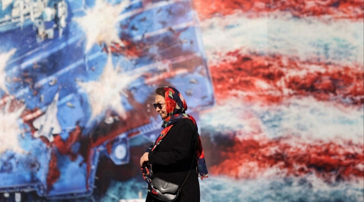 An Iranian woman walks past an anti-U.S. billboard in Tehran, Iran, February 26, 2026. (Majid Asgaripour/WANA (West Asia News Agency) via Reuters)
