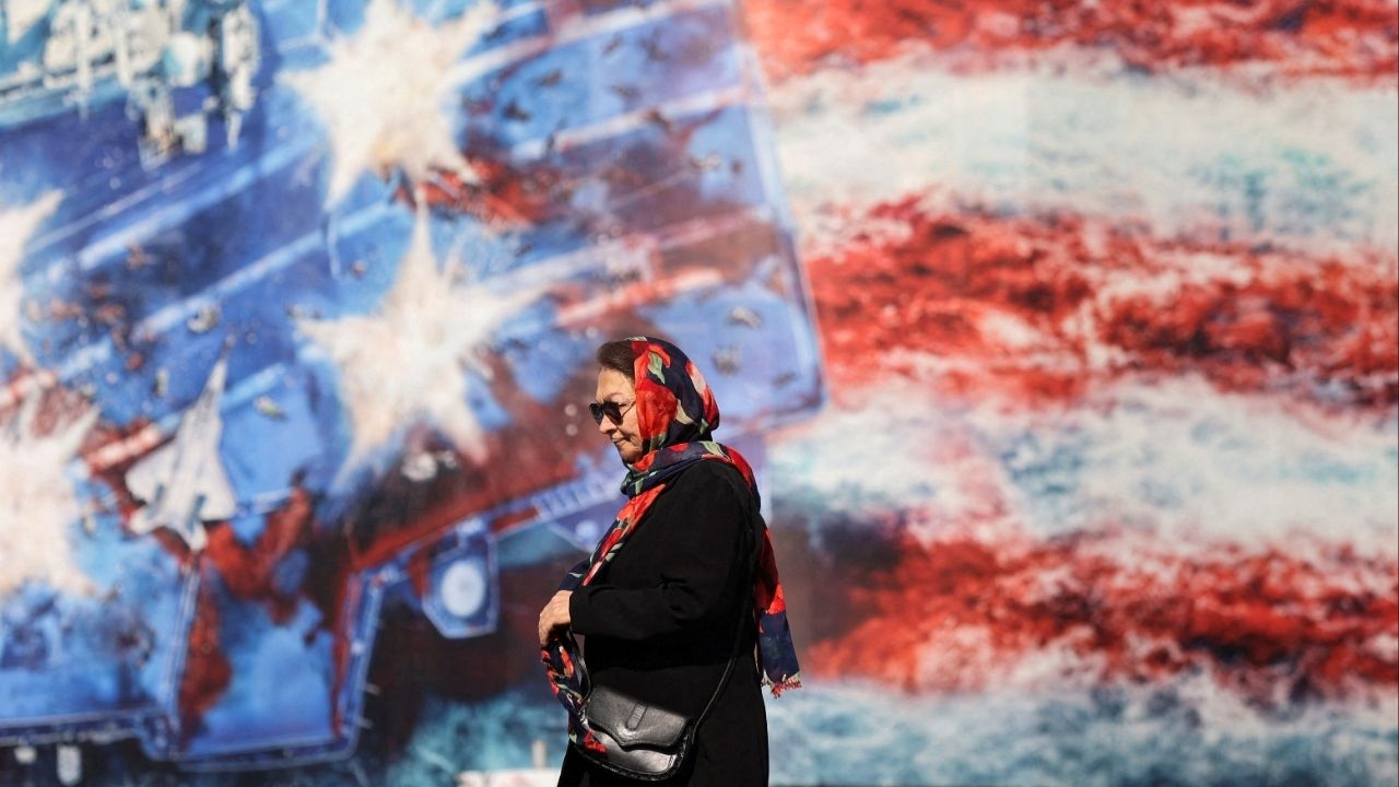 An Iranian woman walks past an anti-U.S. billboard in Tehran, Iran, February 26, 2026. (Majid Asgaripour/WANA (West Asia News Agency) via Reuters)