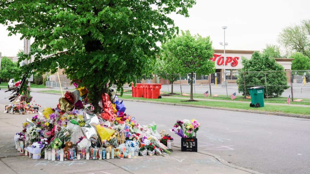 An impromptu memorial set up near the Tops Supermarket, where a gunman shot 13 people, in Buffalo, N.Y., May 20, 2022. The maker of a gun part used in a mass shooting in 2022 agreed to pay $1.75 million to settle lawsuits that said the design of the accessory made it easier for a gunman to kill 10 Black people at a Buffalo supermarket. (Gabriela Bhaskar/ The New York Times)