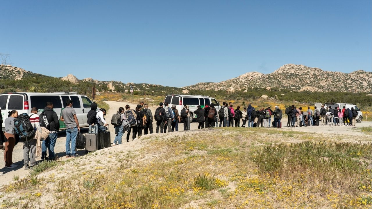 Asylum-seeking migrants line up near the border while waiting to be transported by the U.S. Border Patrol after crossing the border from Mexico into the U.S. in Jacumba Hot Springs, California, U.S. April 29, 2024. (Reuters/Go Nakamura)