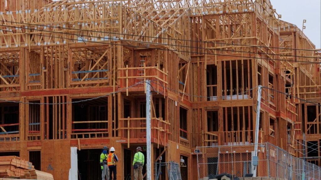 Constriction workers stand in front of a multi-unit residential housing development in Encinitas, California, U.S., October 6, 2025. (Reuters/Mike Blake)