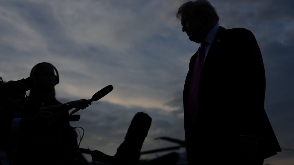 Silhouette image of Donald Trump talking to reporters
