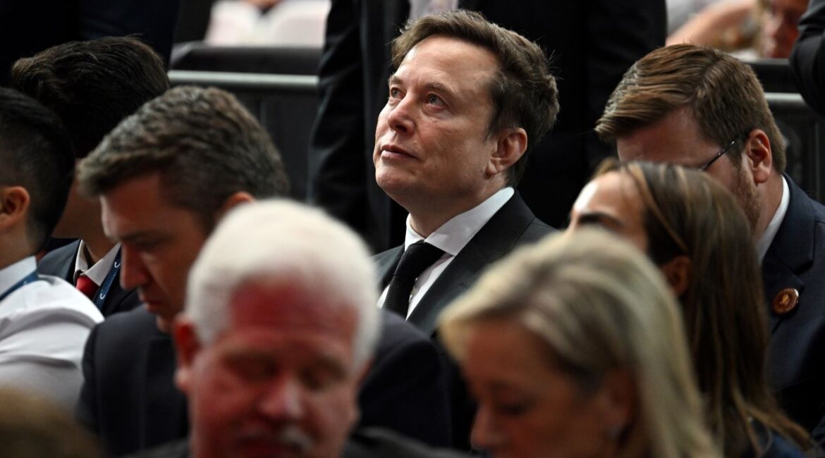 Image of Elon Musk surrounded by a crowd of people