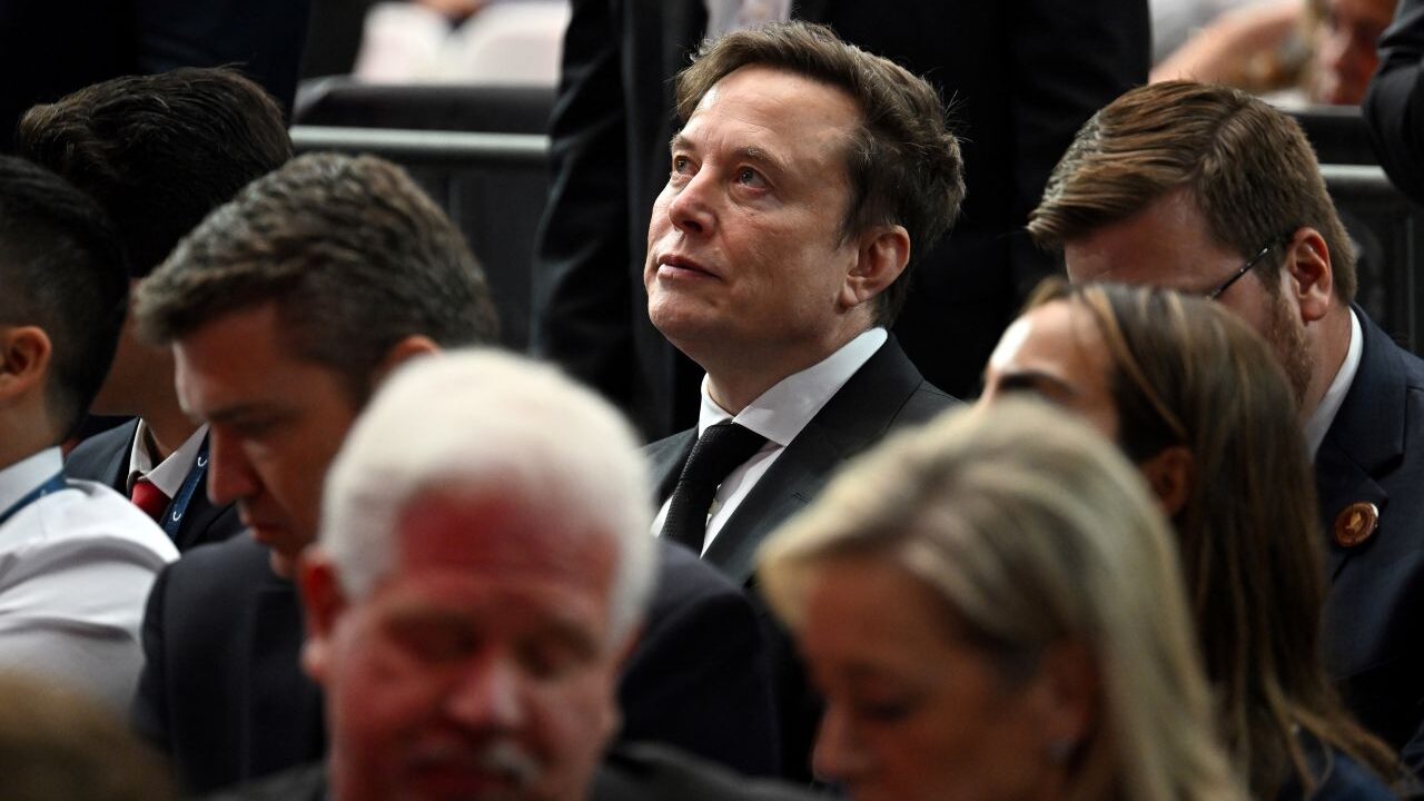 Image of Elon Musk surrounded by a crowd of people