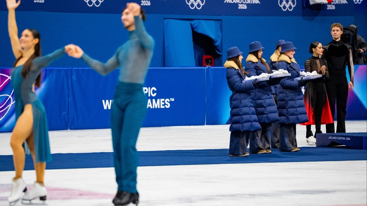 Evan Bates and Madison Chock, right, of the U.S., who won silver, look on as Laurence Fournier Beaudry and Guillaume Cizeron of France greet the crowd after winning gold in the final of the figure skating ice dance free dance during the 2026 Milan Cortina Winter Olympics at the MSK-Competition Rink in Milan, on Wednesday, Feb. 11, 2026. (Vincent Alban/The New York Times)