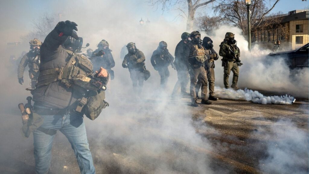 Federal agents confront protestors in Minneapolis, near the site where federal agents shot and killed a 37-year-old Minneapolis resident, Jan. 24, 2026. The U.S. government partially shut down over the weekend, as part of a continuing clash over the Trump administration’s immigration policies after federal agents killed two American citizens in Minnesota. (David Guttenfelder/The New York Times)