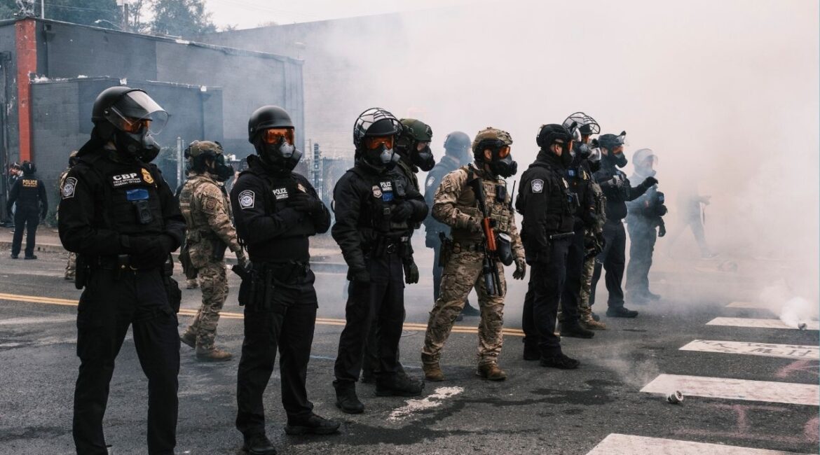 Federal agents faced off with protesters outside a federal detention center in Portland, Ore., Oct. 18, 2025. The tear-gassing this weekend in Portland, Ore., of a protest billed as “family friendly” has prompted Portland’s mayor and City Council to consider dramatic new steps, including financial penalties, to try to force Immigration and Customs Enforcement out of the city. (Jordan Gale/The New York Times)