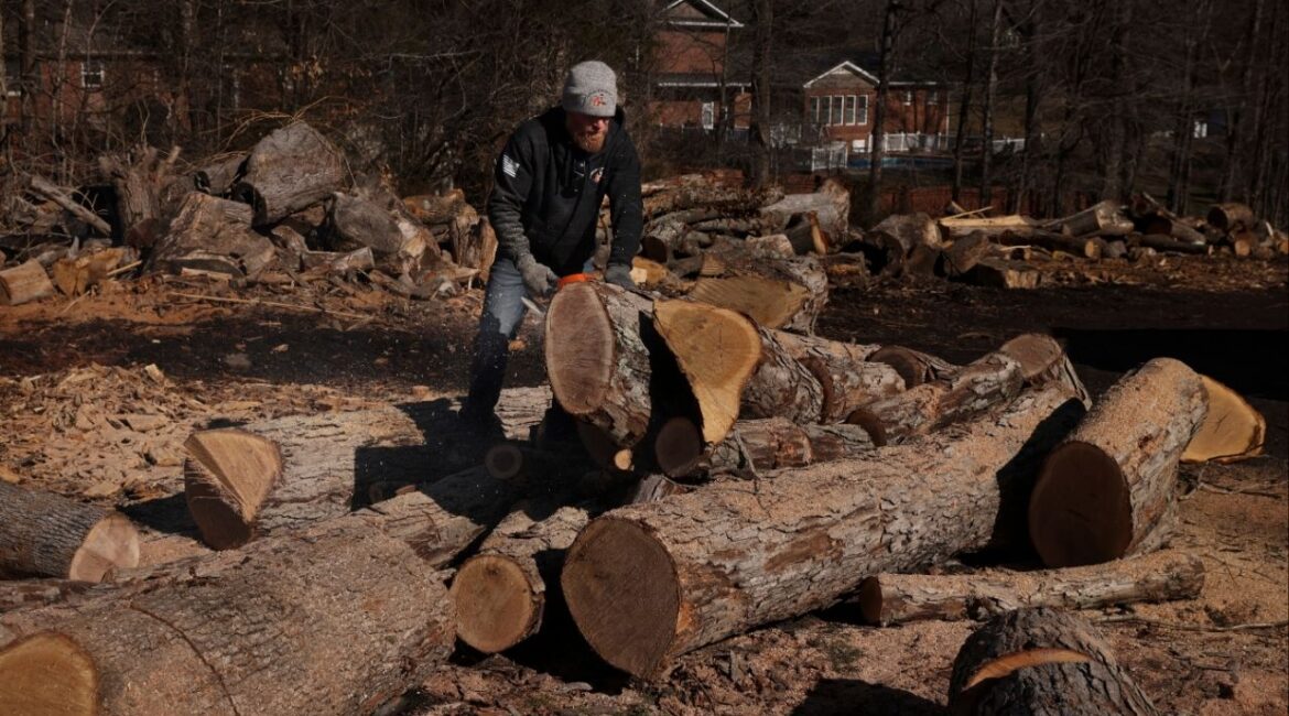 Jason Loflin prepares firewood for customers at one of his lots in Thomasville, N.C., where demand was high enough recently that he recruited friends from his gym for help, on Feb. 13, 2026. Weeks of freezing temperatures and winter storms across parts of the United States have increased the demand for firewood and manufactured fire logs. (Travis Dove/The New York Times)