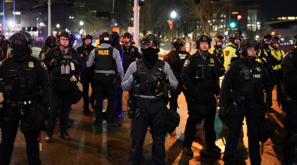 Local and state police stand guard after declaring unlawful assembly, as demonstrators gathered outside a hotel they believe is being used by federal agents, amid increased immigration enforcement in Minneapolis, Minnesota, U.S., February 5, 2026. (Reuters/Seth Herald)