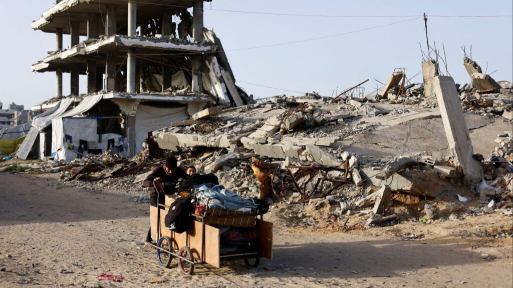 Palestinians push a cart past the rubble of residential buildings destroyed during the two-year Israeli offensives, in Gaza City, February 17, 2026. (Reuters/Mahmoud Issa)