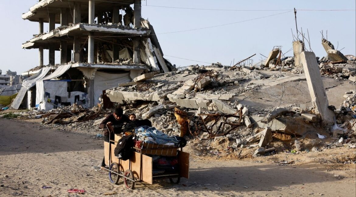 Palestinians push a cart past the rubble of residential buildings destroyed during the two-year Israeli offensives, in Gaza City, February 17, 2026. (Reuters/Mahmoud Issa)