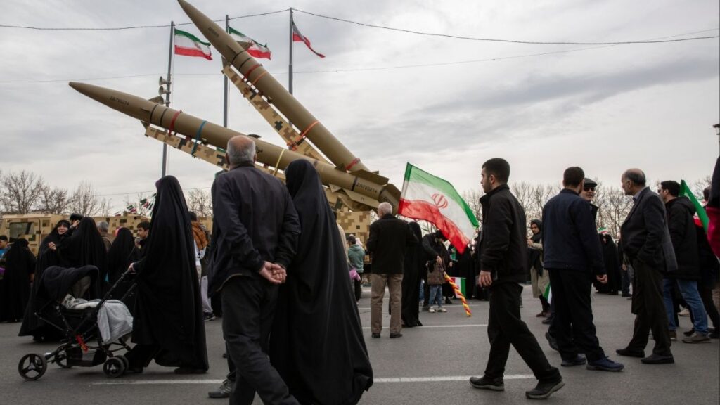 People pass missiles on display during a march marking the anniversary of the Islamic revolution in Tehran, Feb. 11, 2026. The government in Tehran sees capitulating to Washington’s demands on uranium enrichment and ballistic missiles as riskier to its survival than going to war, analysts say. (Arash Khamooshi/The New York Times)