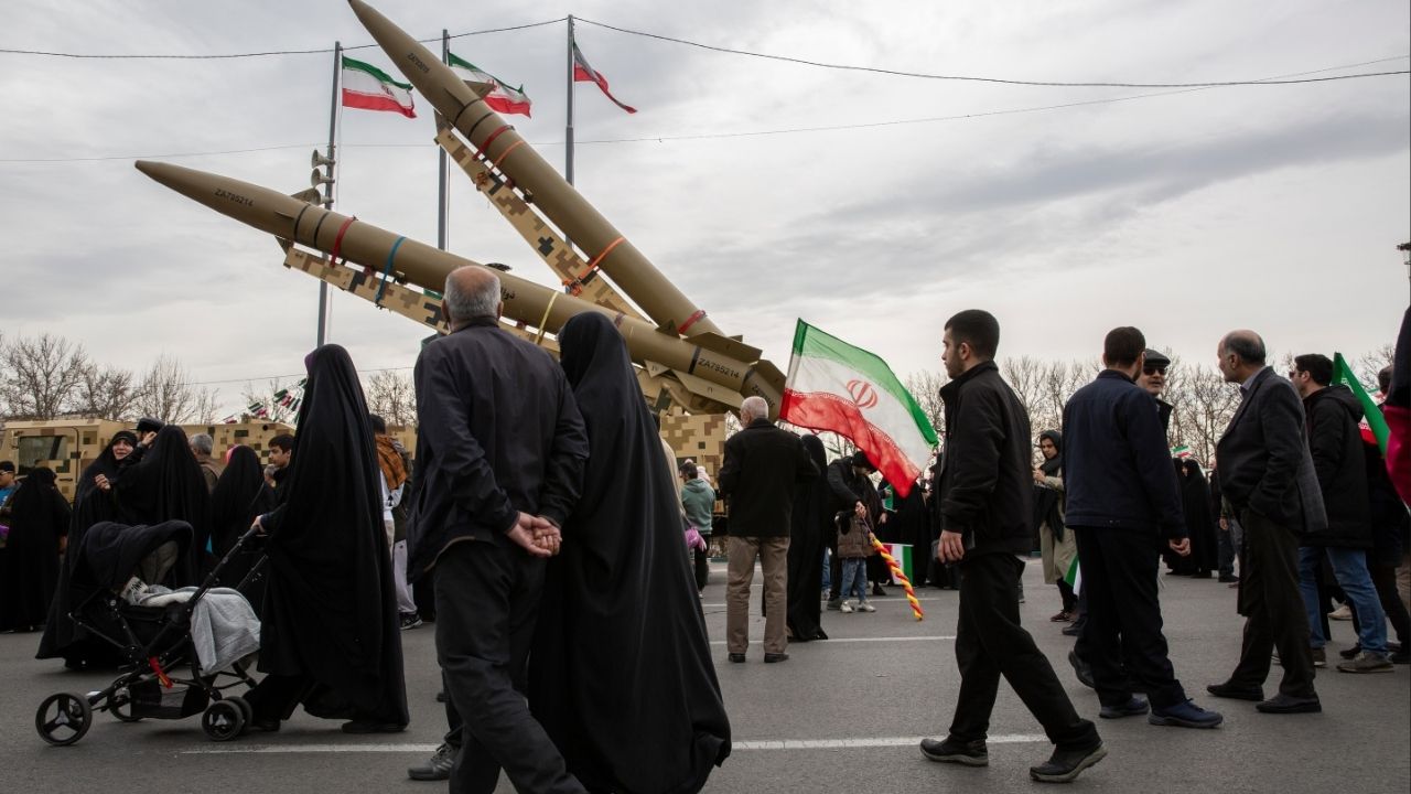 People pass missiles on display during a march marking the anniversary of the Islamic revolution in Tehran, Feb. 11, 2026. The government in Tehran sees capitulating to Washington’s demands on uranium enrichment and ballistic missiles as riskier to its survival than going to war, analysts say. (Arash Khamooshi/The New York Times)
