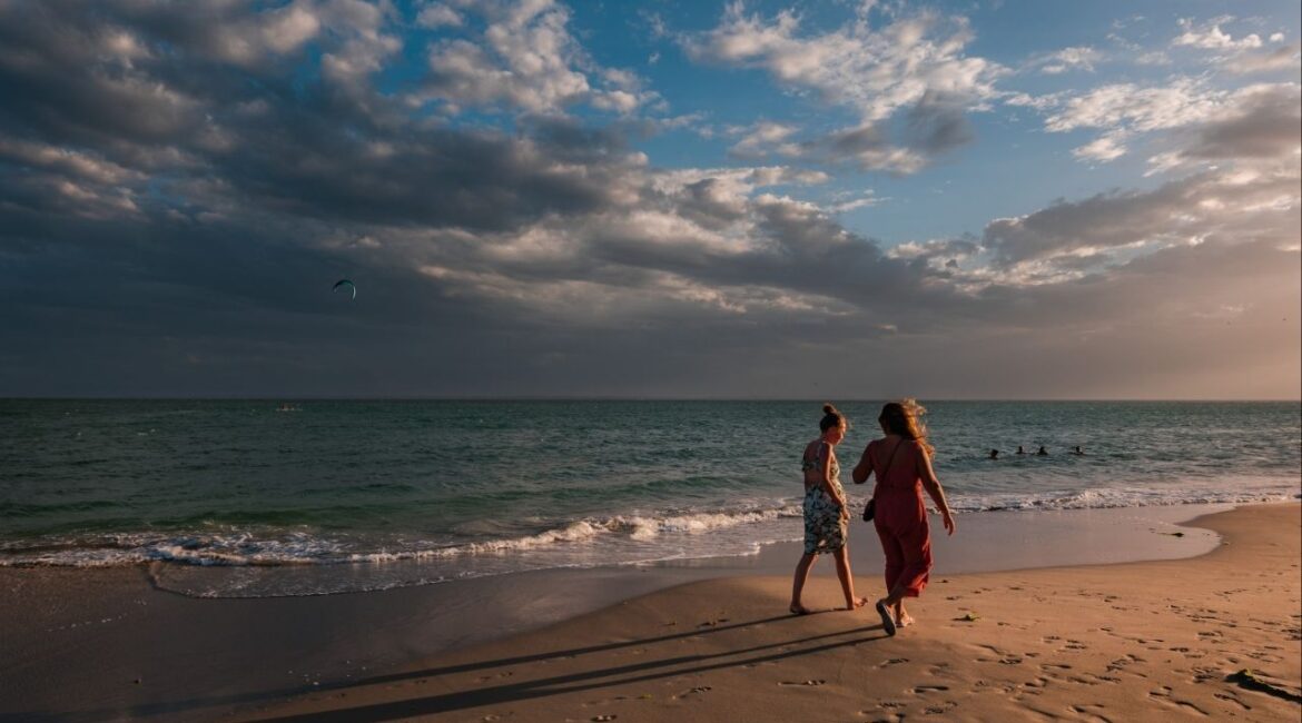 People walk along a beach on Margarita Island, off the Caribbean coast of Venezuela, Feb. 1, 2022. In tourist-heavy regions like Margarita Island, brokers estimate that about 80 percent of current inquiries are from Venezuelans living abroad, with more limited interest from foreign buyers. (Adriana Loureiro Fernandez/The New York Times)