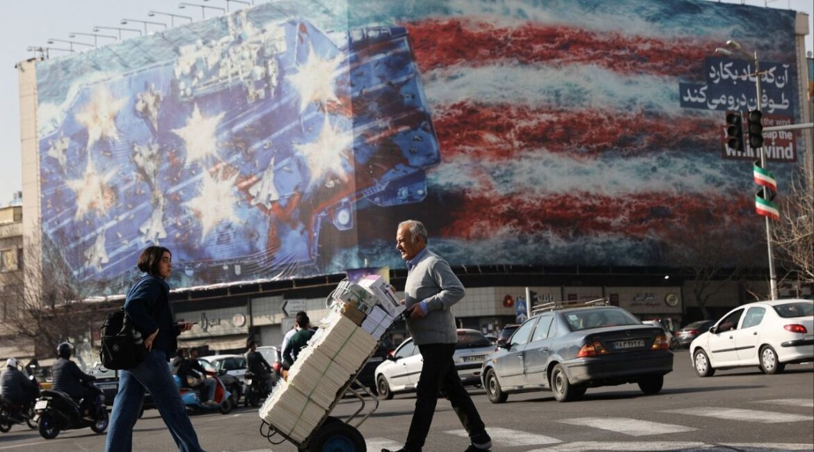 People walk past an anti-U.S. billboard in Tehran, Iran, February 19, 2026. (Majid Asgaripour/WANA (West Asia News Agency) via Reuters)