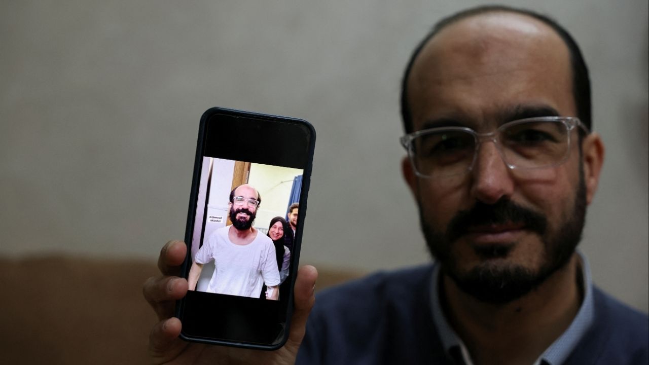 Samer Khaweireh, 45, shows a photo of how he appeared the day he was released from prison four weeks ago after he said he lost 22 kilos of weight in nine months, as he sits in his home in Nablus in the Israeli-occupied West Bank, February 11, 2026.REUTERS/Ammar Awad