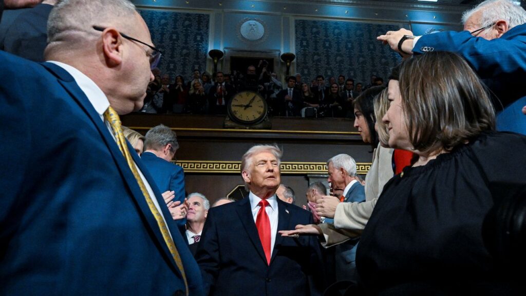 Image of President Donald Trump walking between Republican lawmakers