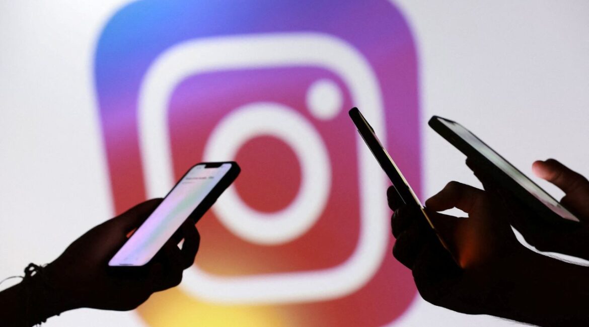 Teenagers pose for a photo while holding smartphones in front of a Facebook logo in this illustration taken September 11, 2025. (Reuters/Dado Ruvic/Illustration/File Photo)
