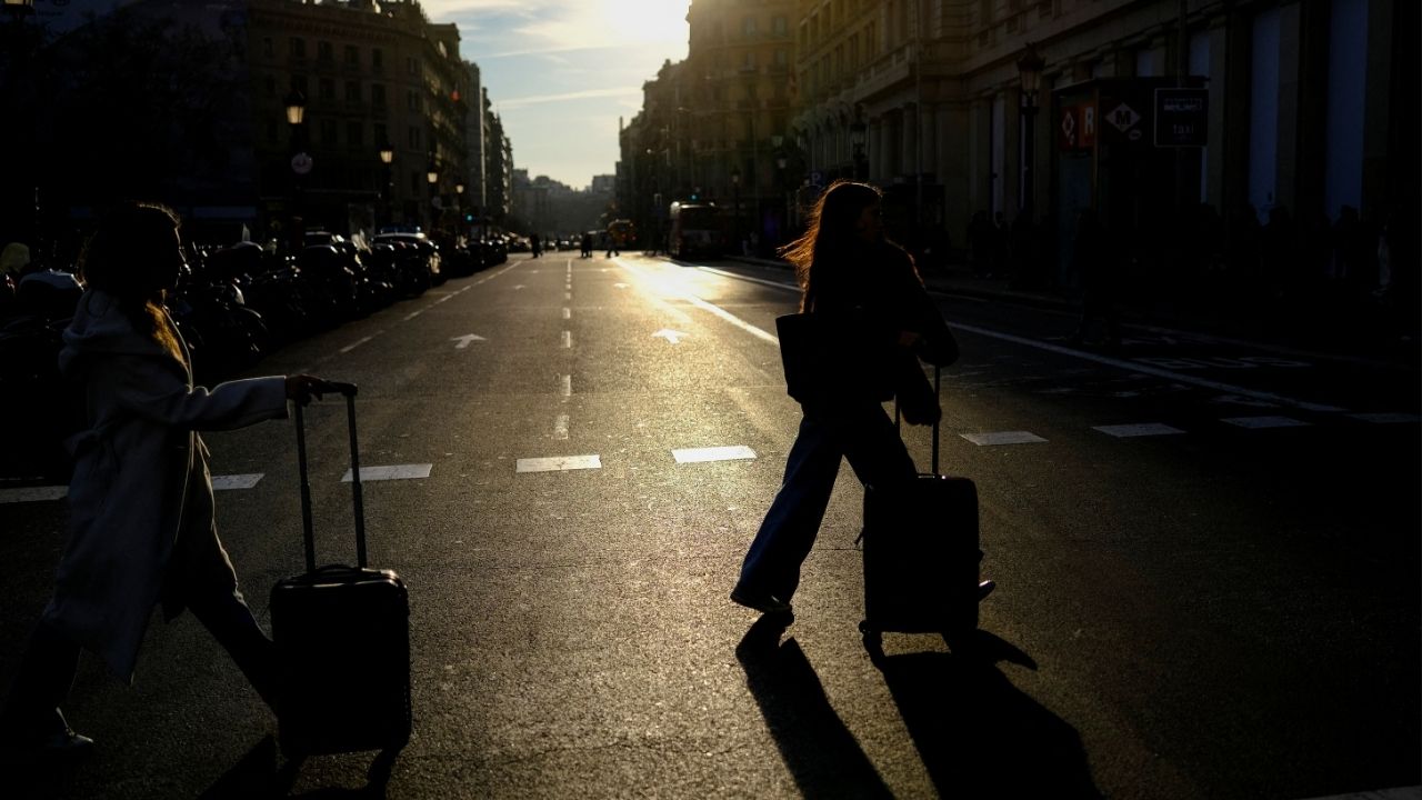 Tourists push their luggage as they arrive at Catalonia Square in Barcelona, Spain February 24, 2026. (Reuters/Nacho Doce)