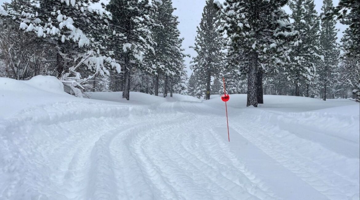 Tread marks from Snow Cat vehicles carrying rescue teams lead into a closed trail at Alder Creek Adventure Center, one of two sites where search crews were launched to try to locate a group of missing skiers after an avalanche in a backcountry slope of California's Sierra Nevada mountains, in Truckee, California, U.S. February 18, 2026. (Reuters/Jenna Greene)