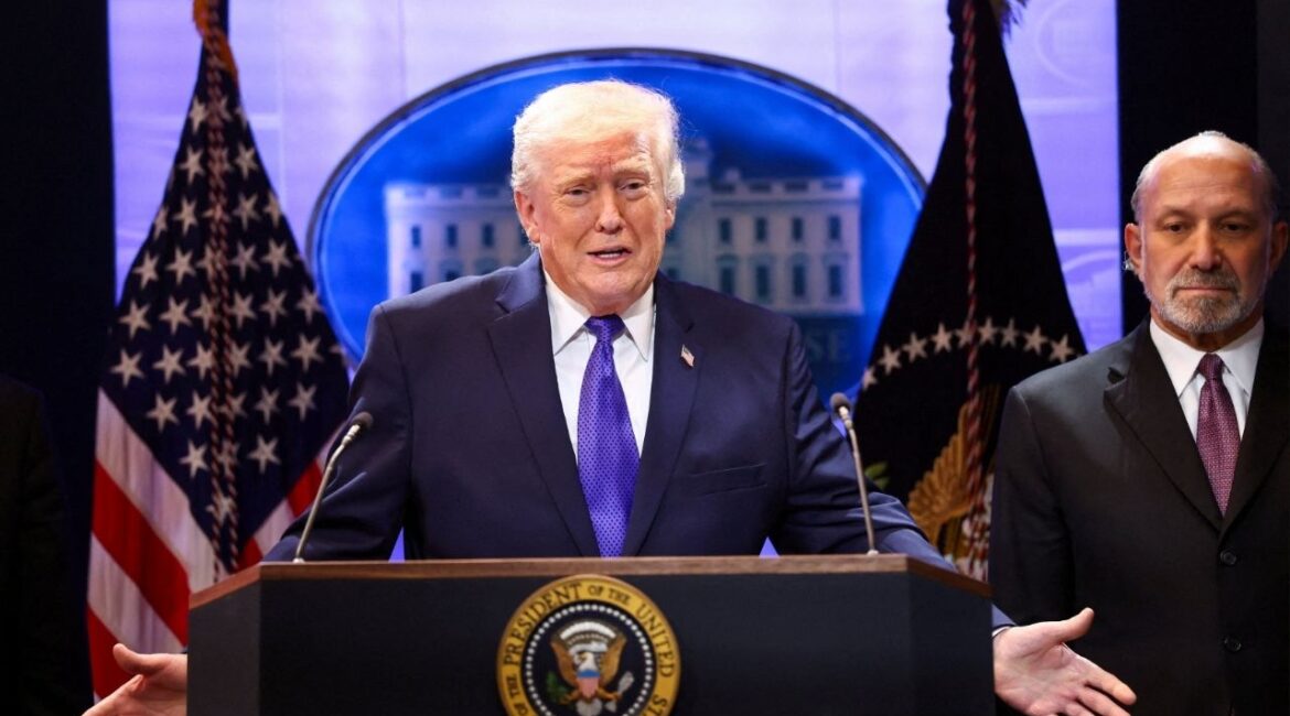 U.S. President Donald Trump, flanked by Secretary of Commerce Howard Lutnick speaks during a press briefing at the White House, following the Supreme Court's ruling that Trump had exceeded his authority when he imposed tariffs, in Washington, D.C., U.S., February 20, 2026. (Reuters/Kevin Lamarque)