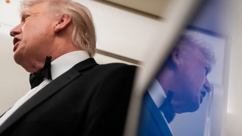 U.S. President Donald Trump is reflected in a television screen while speaking with members of the media on board Air Force One en route to Palm Beach, Florida, U.S., January 31, 2026. (Reuters/Nathan Howard)
