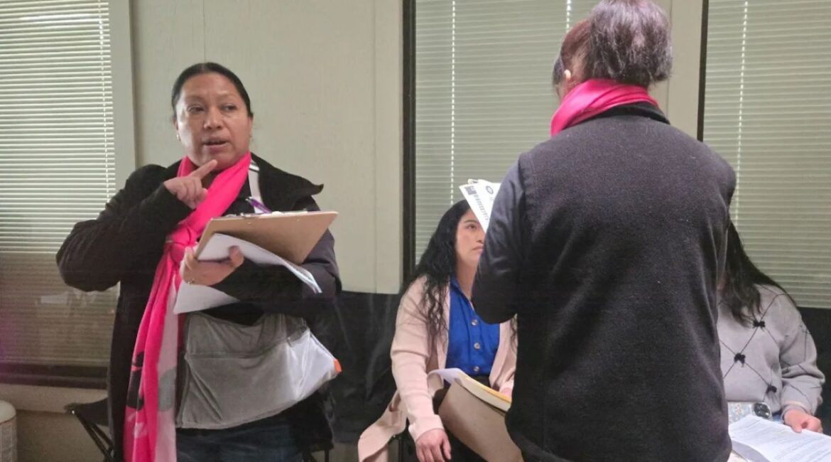 Image of Cultiva Central Valley promotora Analilia Moreira with a pink scarf around her neck and documents in hand